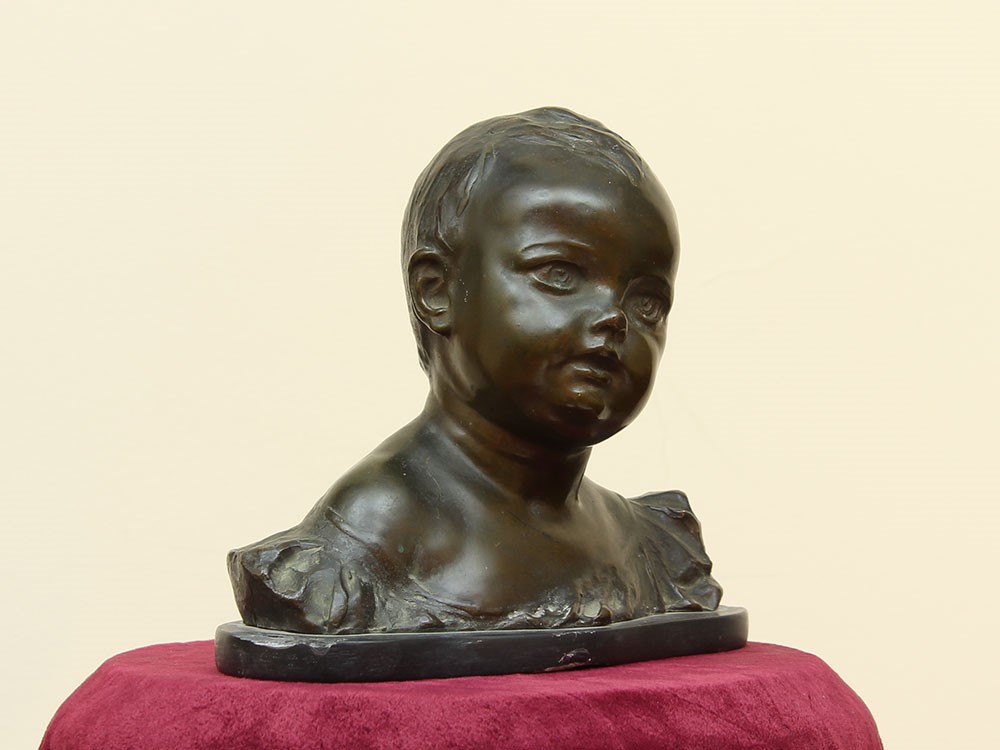 Statua raffigurante testa di bambino in bronzo