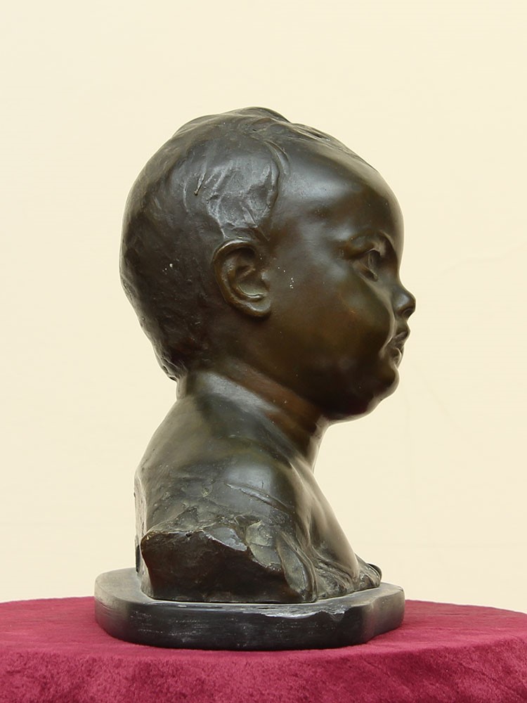 Statua raffigurante testa di bambino in bronzo