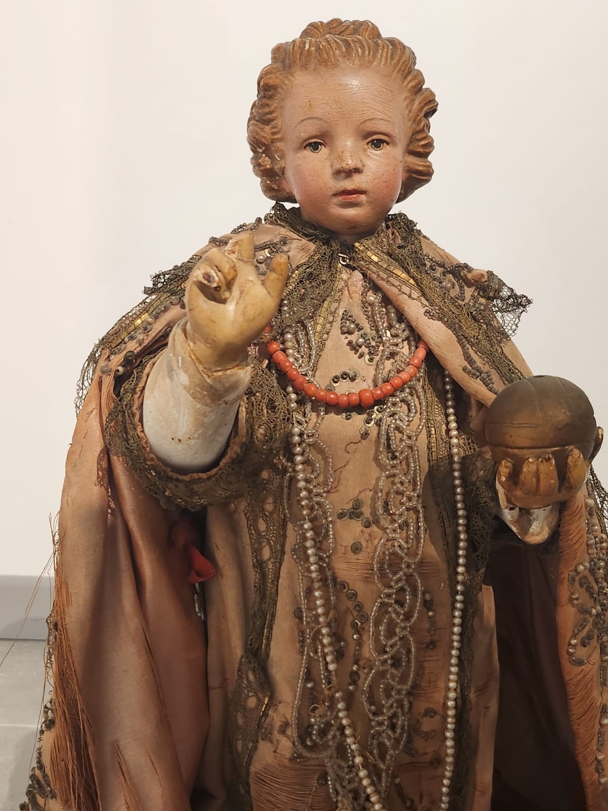 Bambinello in terracotta con vesti con intarsi e collana in corallo