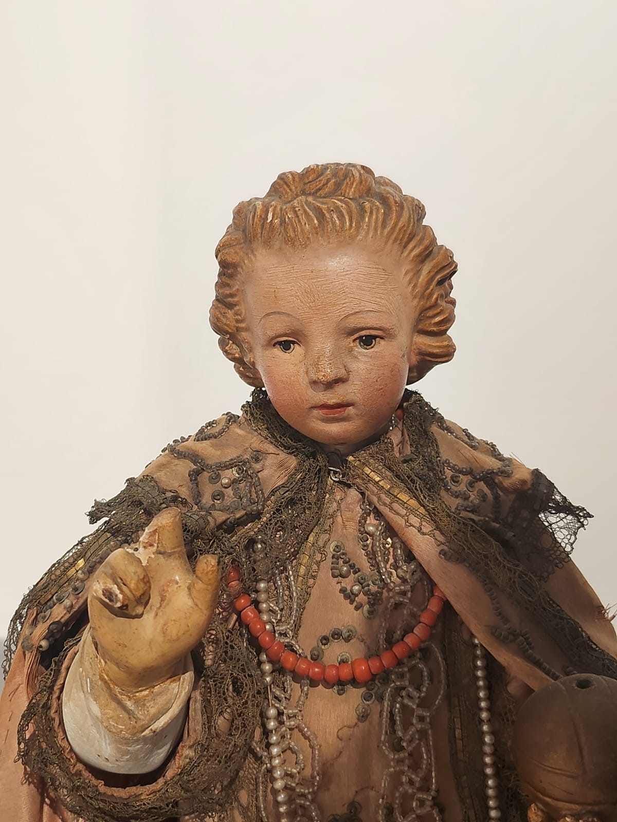 Bambinello in terracotta con vesti con intarsi e collana in corallo