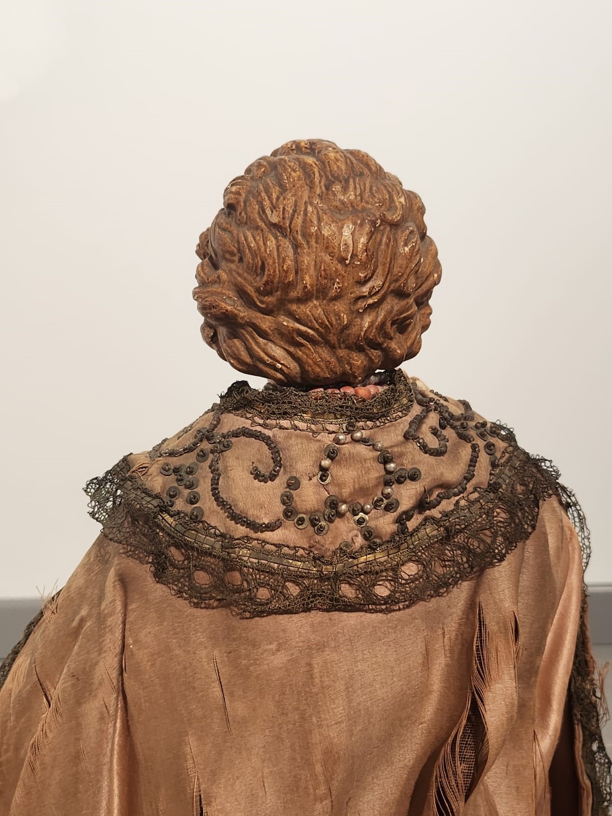 Bambinello in terracotta con vesti con intarsi e collana in corallo