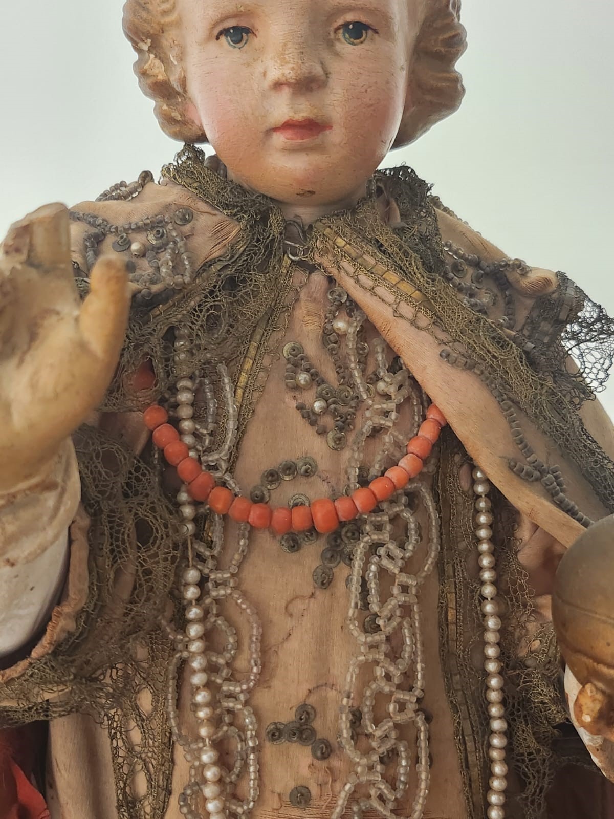 Bambinello in terracotta con vesti con intarsi e collana in corallo