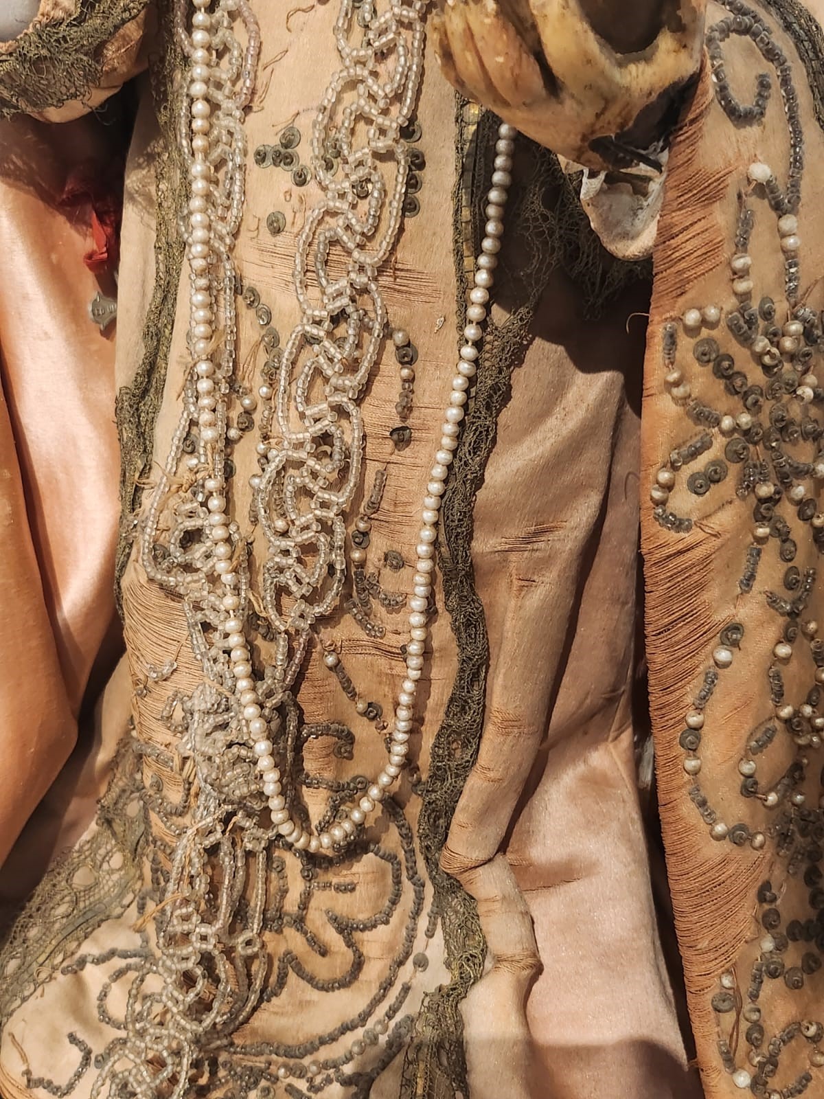 Bambinello in terracotta con vesti con intarsi e collana in corallo